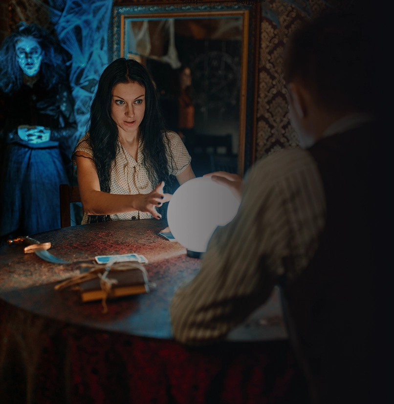 Een vrouw met een kristallen bol en een spook op de achtergrond.